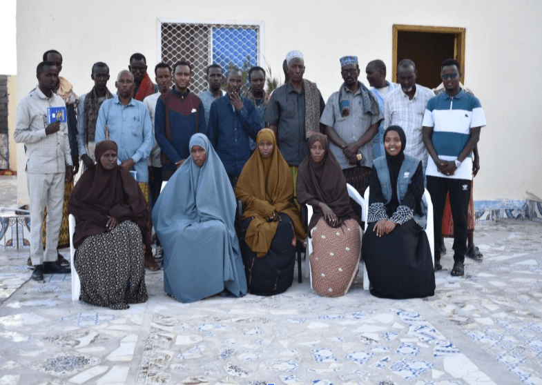 A group of beneficiaries from ADRA’s food distribution programme in Somalia gather for a photo outside a local facility.